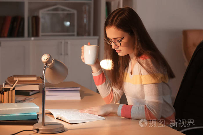 晚上在餐桌上看书的少妇喝咖啡