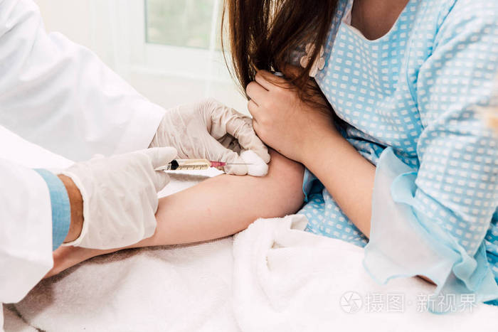 医生在医院的医生桌上给小女孩注射了防护手套. 保健和医药