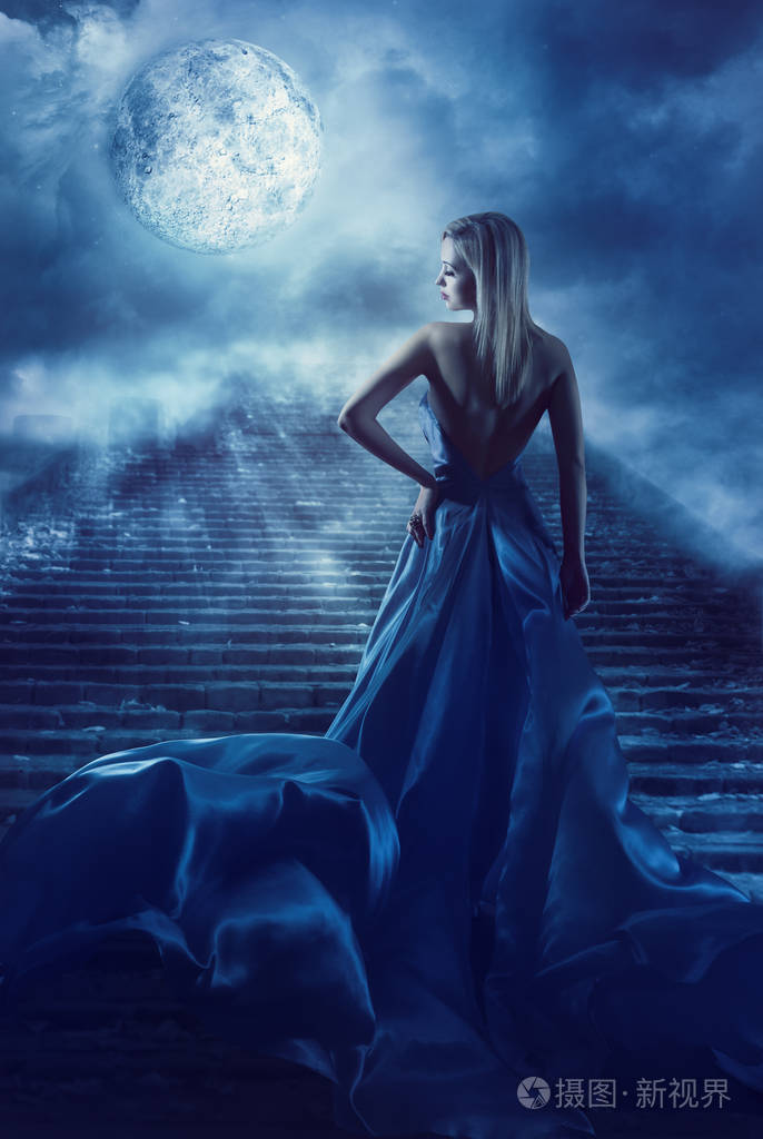 女人爬上楼梯到幻想月亮天堂,在夜的童话女孩蓝色连衣裙