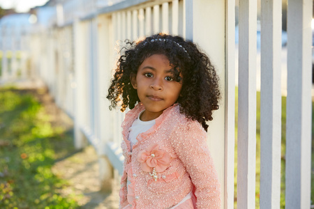 快乐蹒跚学步的孩子女孩画像在公园围栏