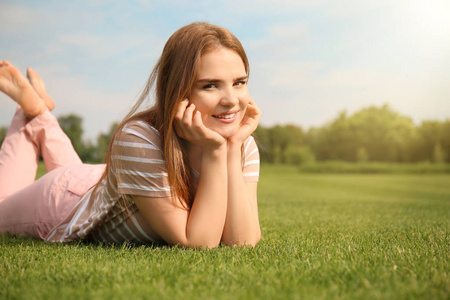 在户外草坪上放松的年轻女子