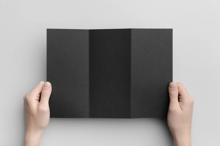 黑色 A4 Z 折叠小册子模拟男性手拿着黑色三折叠灰色背景