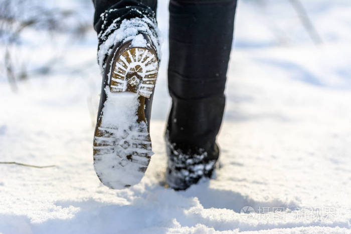 冬季雪地行走中的女性脚靴