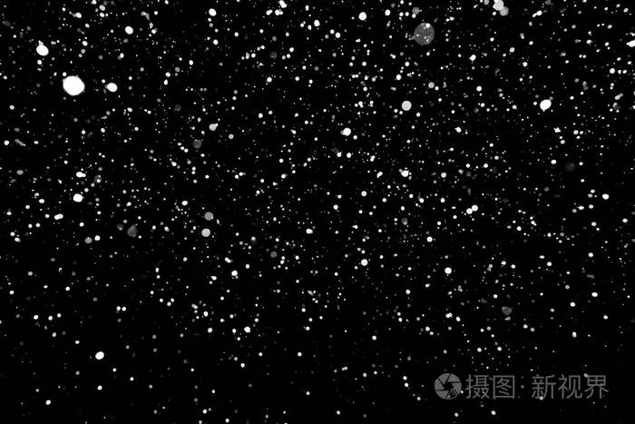 暴风雪的纹理.在黑色背景上的散景灯拍摄的飞片雪花在空中