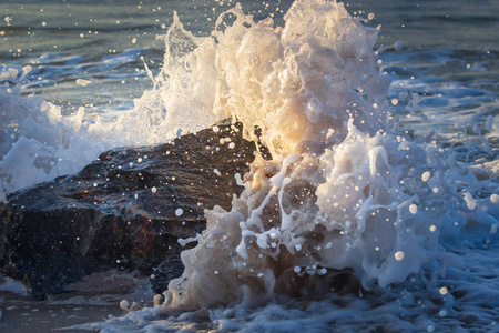 强大的海浪破碎岩石的海滩上
