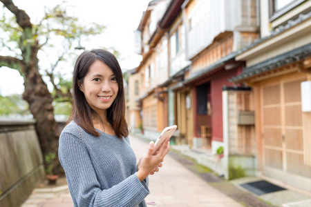 女人参观金泽市和使用手机