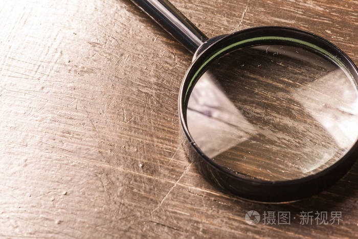 木制的背景上的放大镜