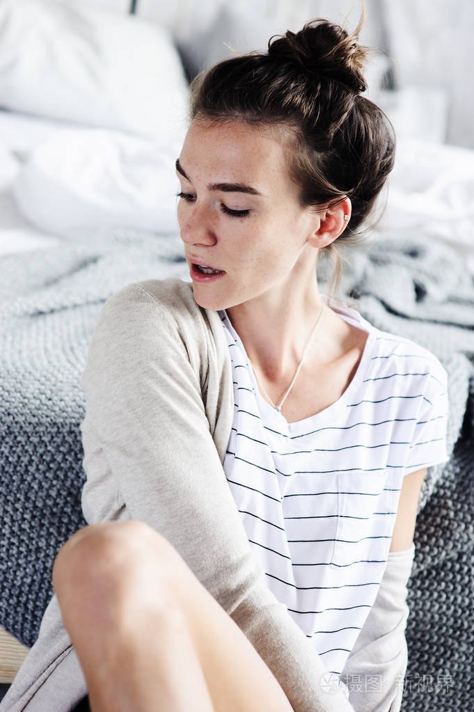 年轻女性性感美女懒周末早上在卧室里放松,穿休闲时尚的衣服