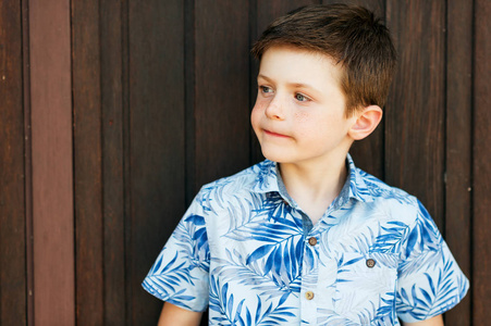 有趣时尚的孩子男孩摆在户外，穿着蓝色印花衬衫