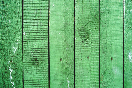 旧篱笆与生锈的钉子的木制背景。破旧的绿色彩色木板纹理