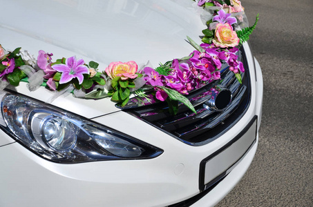 一张详细的汽车罩的照片, 装饰着许多不同的花。汽车准备举行婚礼。