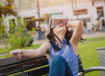 有魅力的年轻女孩在街上戴着虚拟现实眼镜玩游戏。Vr 耳机