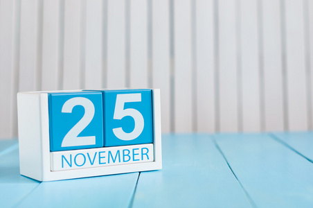 11 月 25 日。11 月 25 日的形象在蓝色背景上的木制彩色日历。秋季的一天。文本为空的空间