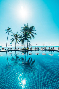 美丽的热带海滩和海与伞和椅子在游泳池附近在旅馆度假胜地为旅行和假期