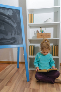 女孩, 一个孩子读一本书坐在粉笔板