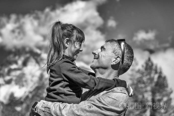 父亲和女儿在一个美丽的山场景中拥抱彼此