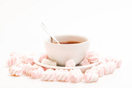茶杯配热饮料和棉花糖。茶歇概念。饮料酿造过程在杯子。杯装黑色酿造茶, 勺子和棉花糖堆在白色背景