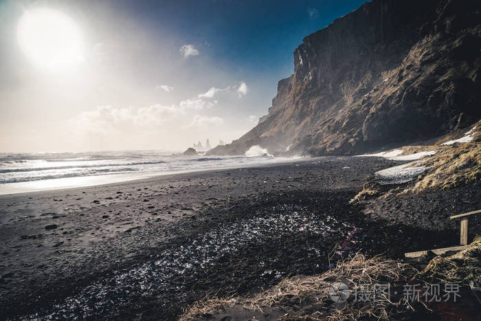 在冰岛著名的黑色沙滩 Reynisfjara 日出。刮风的早晨。海浪。五彩缤纷的天空。早晨日落