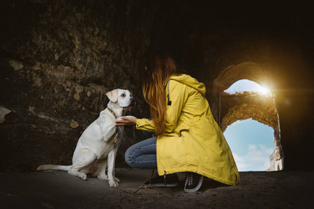 年轻女子和白拉布拉多猎犬犬狗的自然互动