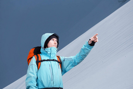 登山者指向上山坡，站在反对一个冬天山风景