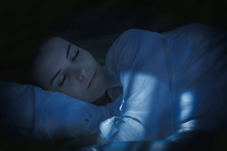 漂亮的女人在床上安静地睡在晚上