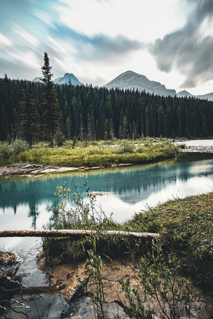 弓河床美丽的蓝色与山在背景和树和预测在前景
