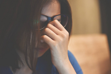 累了的亚洲眼镜女人揉眼睛.复制空间.加班照片