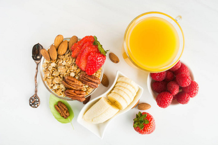 早餐与燕麦, 坚果, 浆果, 香蕉和果汁在白色桌, 平的放置样式