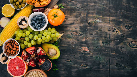 食品。蔬菜, 水果, 坚果和浆果。维生素。在一张旧的木桌上。顶部视图。文本的可用空间