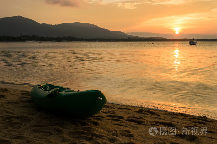 独木舟在海滩上与在泰国苏梅岛上的夕阳