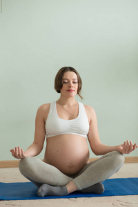 怀孕的女人让莲花瑜伽锻炼