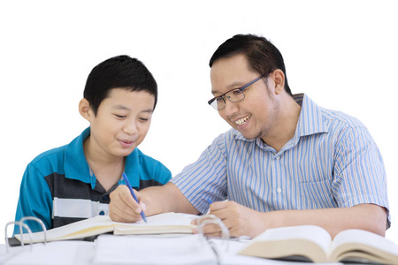 年轻父亲的形象, 帮助他的儿子做家庭作业, 而坐在工作室, 孤立的白色背景