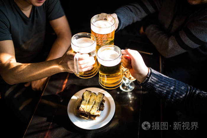 欢呼.特写镜头顶视图的人们手捧杯子喝啤酒