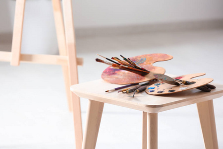 木椅上的专业画家画刀刷子和调色板