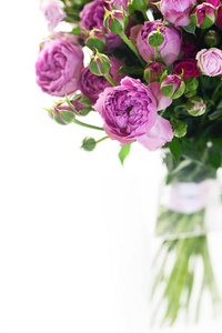 白色背景玻璃花瓶中的粉彩紫罗兰色玫瑰