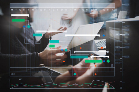 项目经理使用里程碑进度计划和甘特图计划虚拟图来工作和更新任务。启动编程团队。网站设计者工作数字平板电脑坞站键盘
