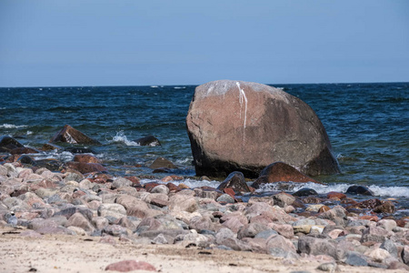 岩石海海滩以宽广的角度透视在海与晴朗的天空和波浪