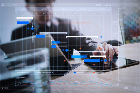 项目经理使用里程碑进度计划和甘特图计划虚拟图来工作和更新任务。商人手摸数码片。照片财务经理工作新投资项目