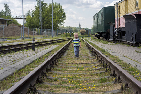 铁轨上的小男孩。阳光明媚的夏日