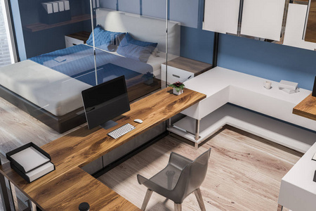 深蓝色的墙壁在卧室里有深蓝色和木质墙壁和电脑桌的紧凑型家庭办公室