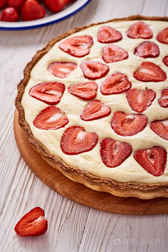 在木制的白色背景上的草莓馅饼