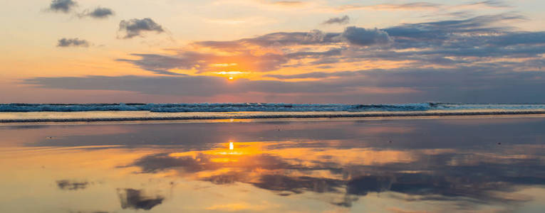日落光和多云的天空反射在水中, 巴厘岛, 库塔海滩