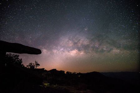 晚上天空的星星背景上石头小屋