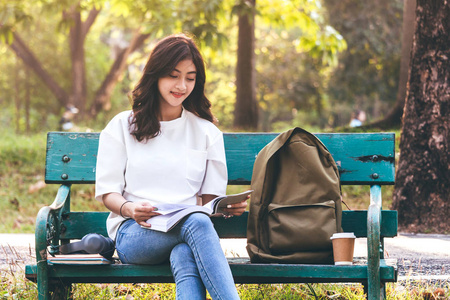 女学生在户外阅读笔记本电脑。教育理念