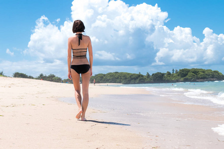 女人在沙滩留下脚印在沙滩上行走。热带巴厘岛印度尼西亚