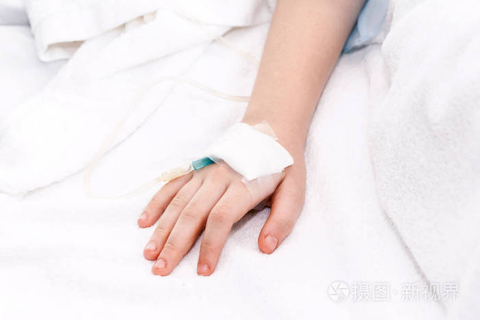 小女孩手与 iv 盐水静脉在医院里