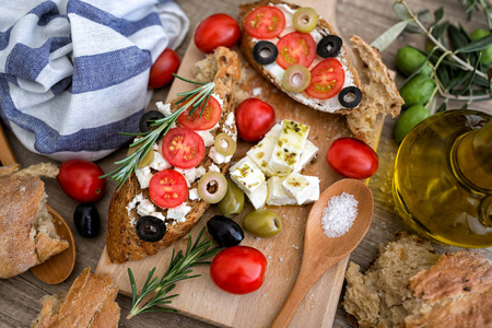 最热门看法意大利 bruschetta 与蕃茄乳酪干酪橄榄和新鲜的菜在切削板