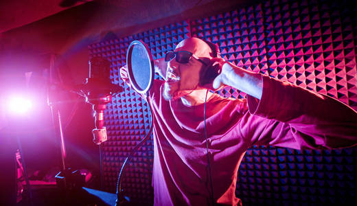 歌手在录音室里用麦克风唱歌.现代背景照片