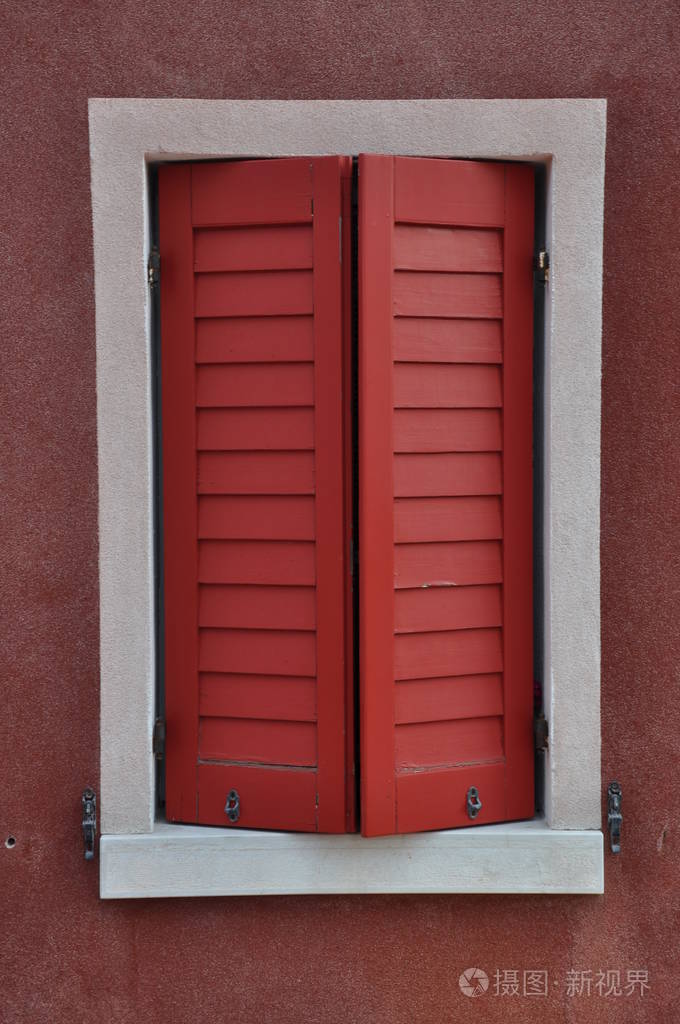 墙上有红色快门的封闭窗口