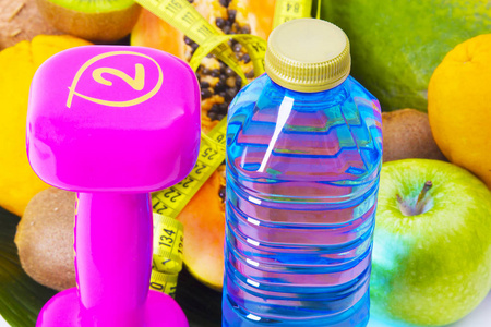 水果, 哑铃, 水瓶和卷尺。饮食与健康概念